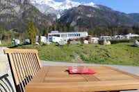 Camping Kranebitterhof - Tisch auf dem Campingplatz mit Blick auf die Stellplätze und die Alpen