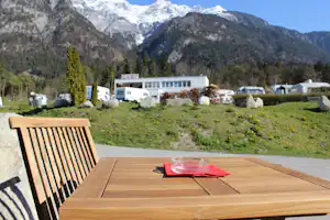 Camping Kranebitterhof - Tisch auf dem Campingplatz mit Blick auf die Stellplätze und die Alpen