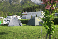 Camping Kranebitterhof - Zelte auf Stellplätzen mit einem Gebäude des Campingplatzes im Hintergrund