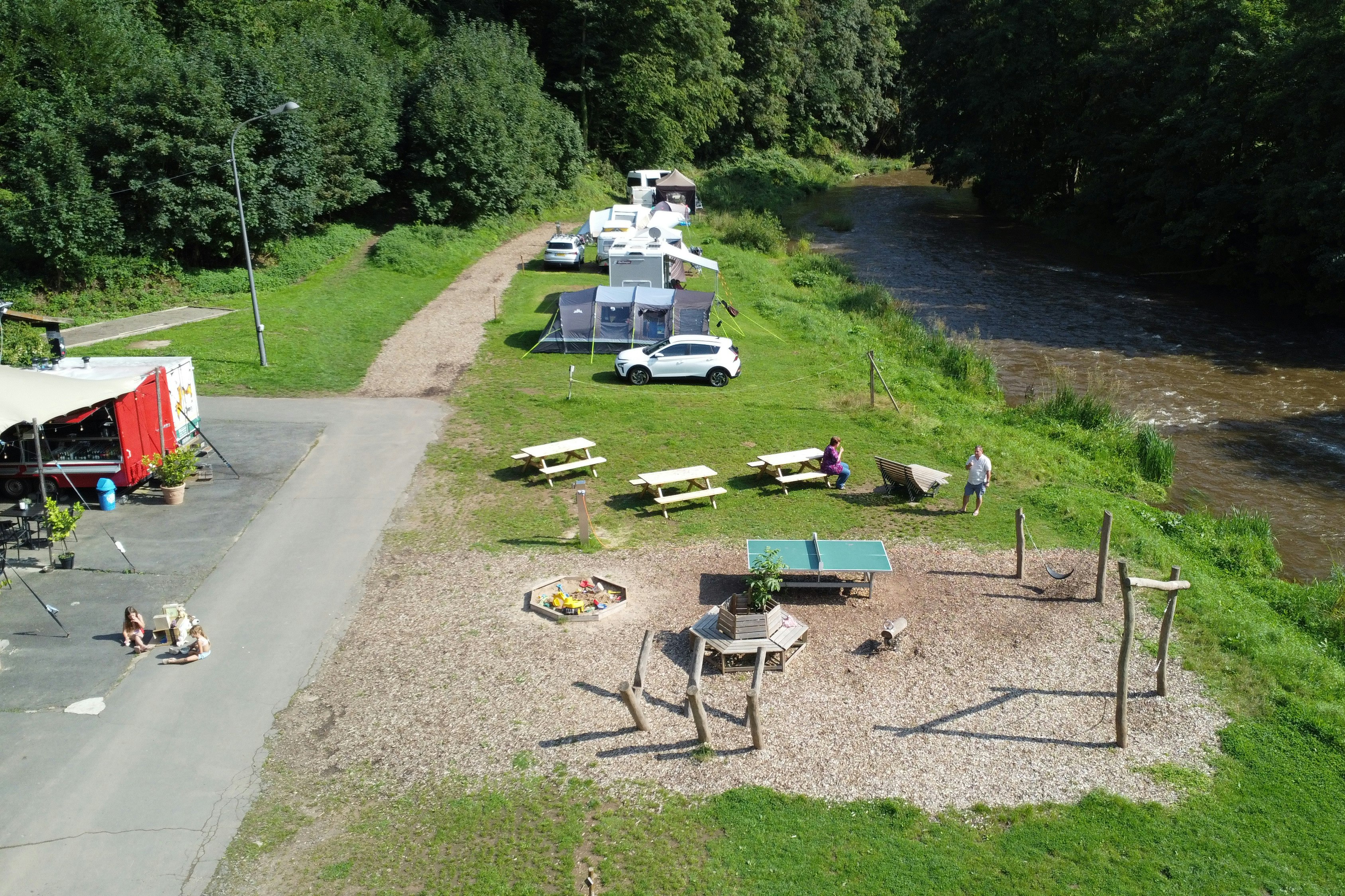 Camp Kyllburg  Camping Kyllburg - Spielplatz mit kleinem Sandkasten, Geräten und Tischtennisplatte