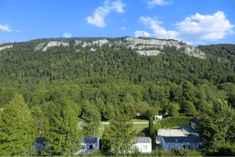 Camping L' Abbaye - Überblick auf den Wohnwagen- und Zeltstellplatz vom Campingplatz an einem Felsen