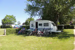 Camping L' Arada Parc - Camper sitzen vor dem Wohnmobil im Schatten auf dem Campingplatz