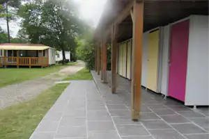 Camping L' Orée du Bois - Sanitärgebäude vom Campingplatz und Mobilheim im Hintergrund