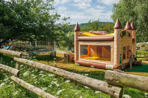 Camping L' Étang de la Fougeraie - Spielplatz vom Campingplatzmit Hüpfburg und Trampolin im Grünen