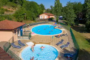 Camping La Bageasse - Pool mit Liegestühlen und Sonnenschirmen auf dem Campingplatz