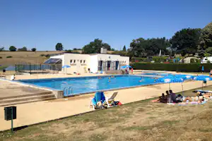 Camping La Bedure - Camper am Pool vom Campingplatz mit Sonnenschirmen und Liegestühlen