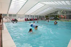 Camping La Belle Étoile - Überdachter Poolbereich vom Campingplatz mit Liegestühlen und Brunnenanlagen