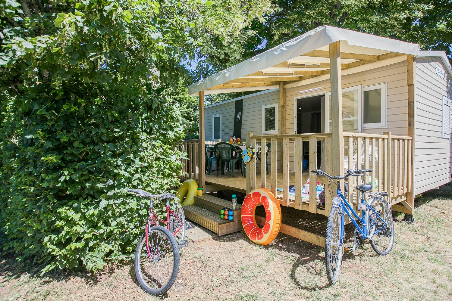 Camping La Bouquerie - Blick auf Mobilheim mit Terrasse im Grünen auf dem Campingplatz