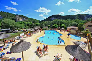 Camping La Bouysse de Caudon - Pool vom Campingplatz mit Sonnenschirmen und Liegestühlen und mit Blick auf die Berge