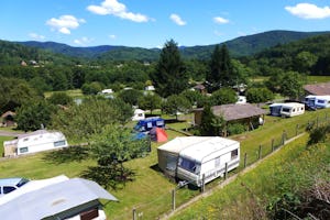 Camping La Broche - Wohnwagen- und Zeltstellplatz zwischen Bäumen auf dem Campingplatz