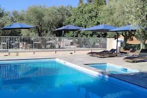 Camping La Camassade - Pool im Freien mit Liegestühlen und Sonnenschirmen