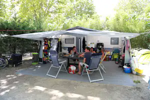 Camping La Chapelle - Camper sitzen vor dem Wohnmobil im Schatten der Markise