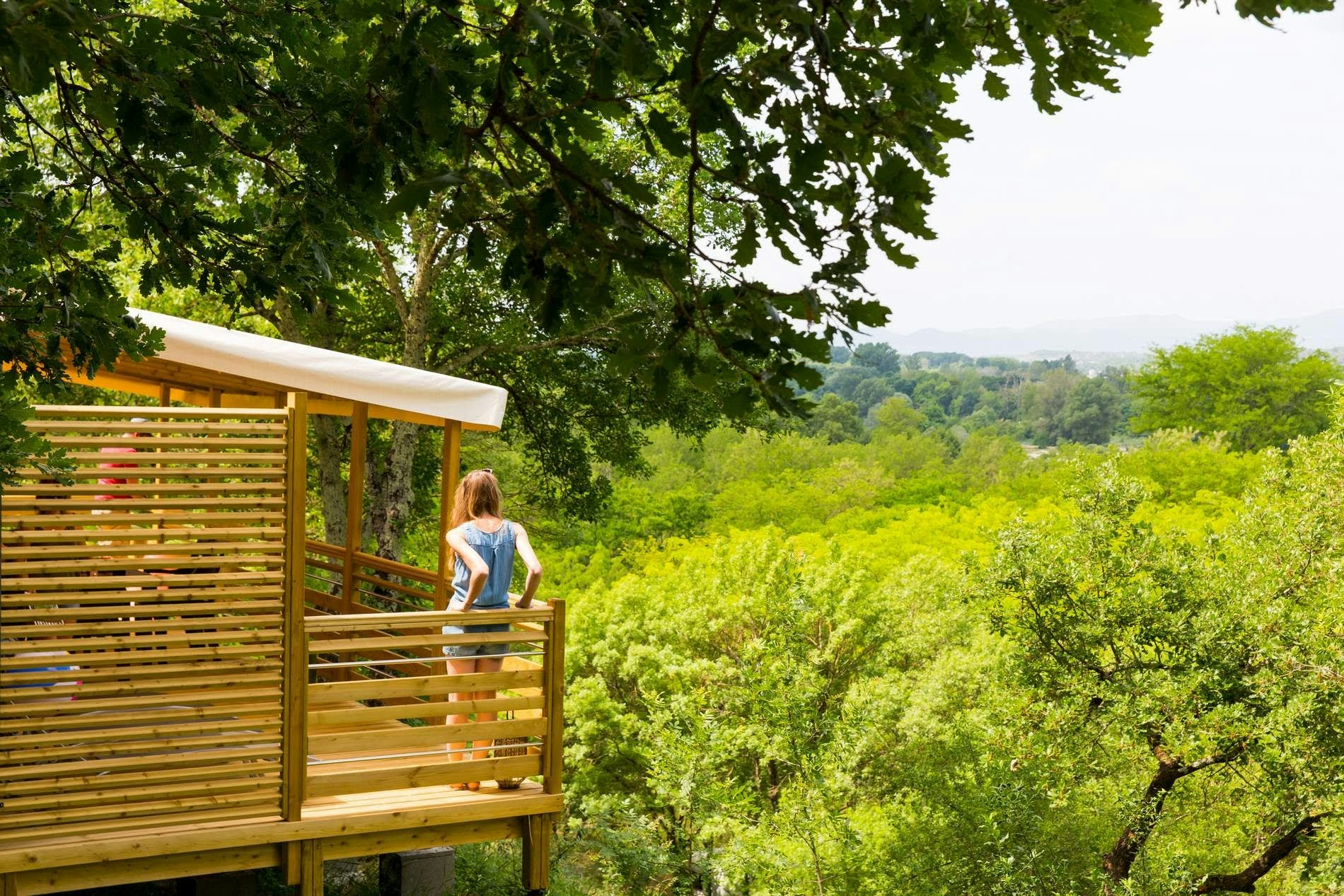 Camping La Chapoulière - Terrasse eines Mobilheims mit Blick auf die umliegenden Bäume