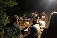 Camping La Châtaigneraie - Gäste beim gemeinsamen Zusammensitzen und Musizieren am Abend