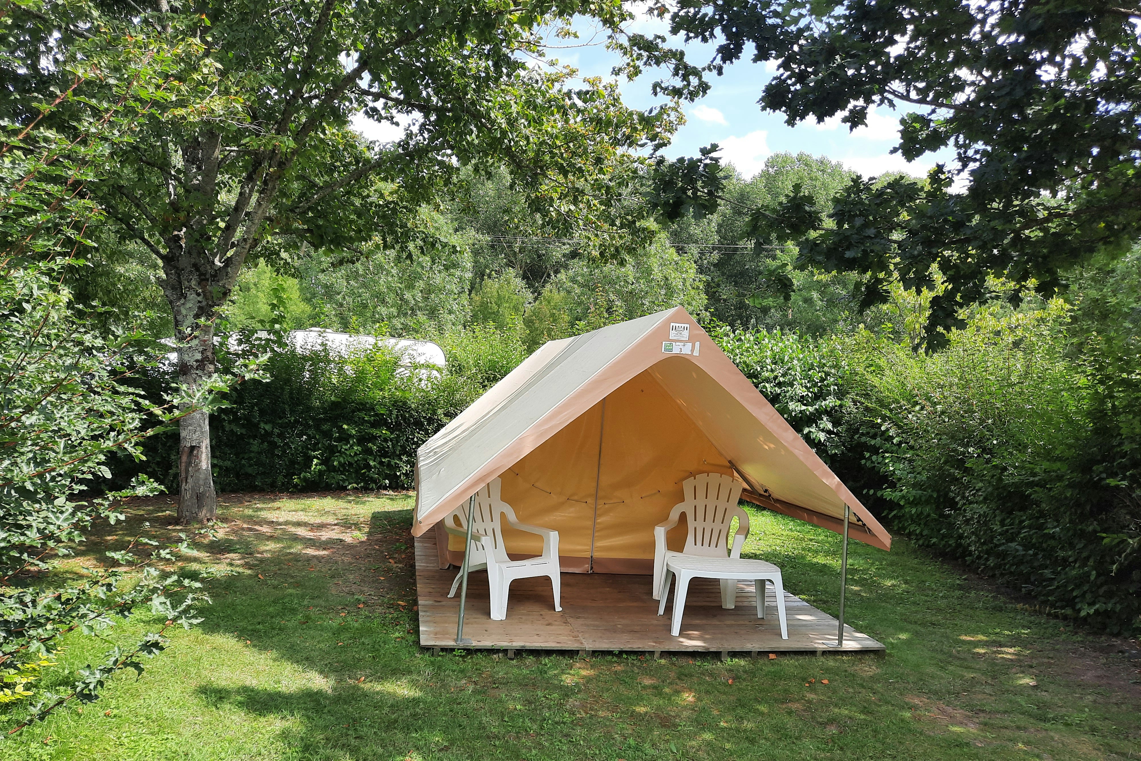 Camping La Confluence - Standplatz mit einem minimalistischen Wohnzelt mit kleiner Terrasse, Vordach und Stühlen
