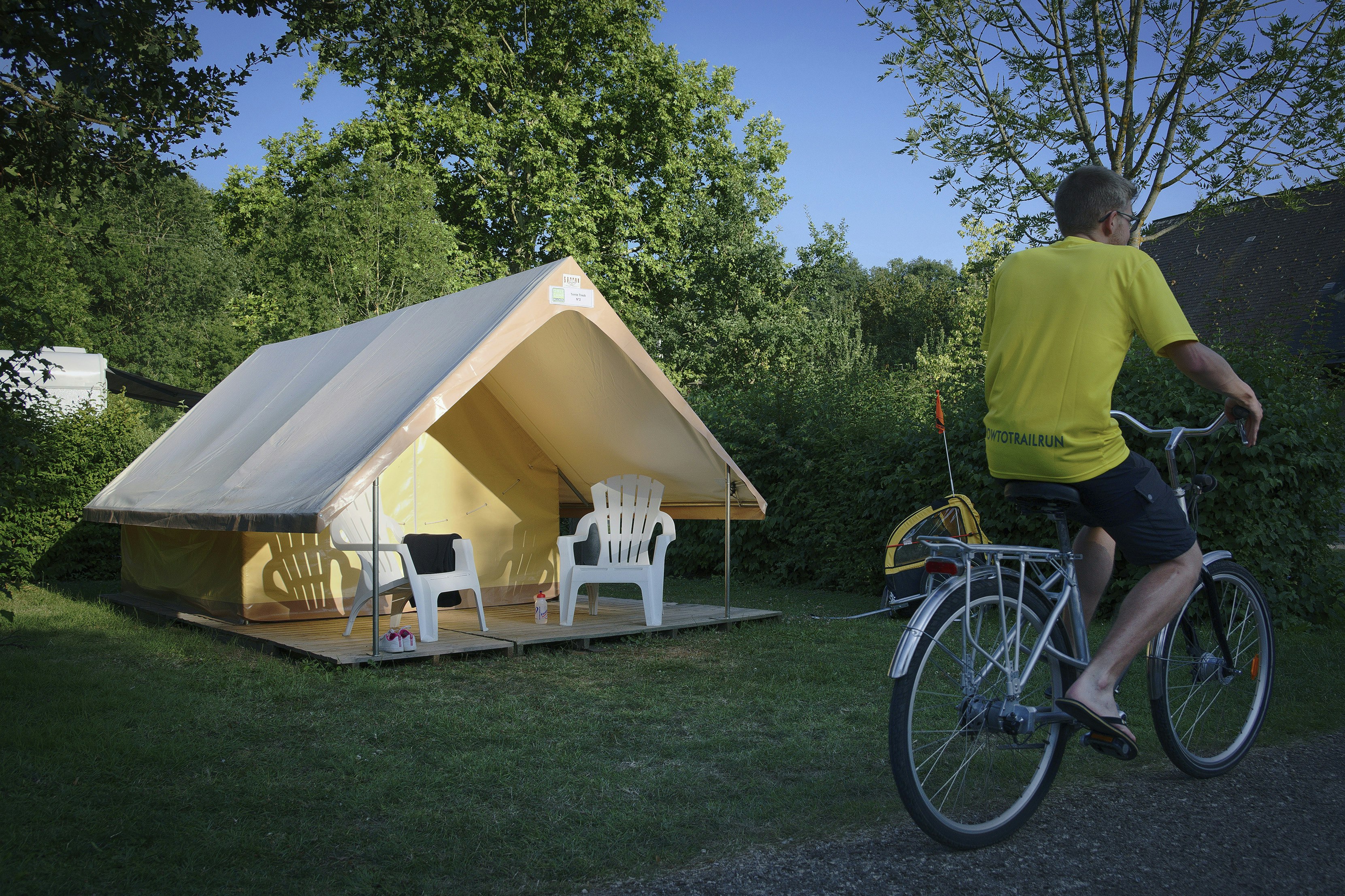 Camping La Confluence - Standplatz mit minimalistischem Wohnzelt mit Vordach, kleiner Terrasse und zwei Stühlen