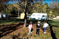 Camping La Cota - Stellplatz zwischen Bäumen auf dem Campingplatz