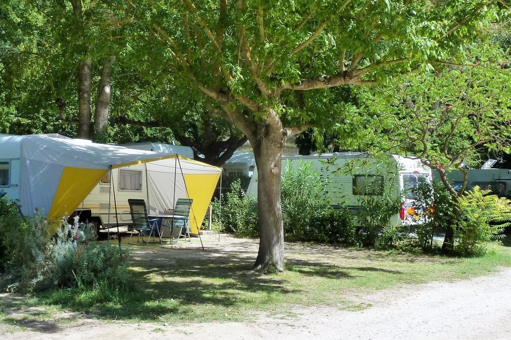 Camping La Coutelière - Zeltplatz und Wohnwagenstellplatz zwischen den Bäumen auf dem Campingplatz