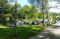 Camping La Faz  -  Wohnwagen- und Zeltstellplatz zwischen Bäumen auf dem Campingplatz