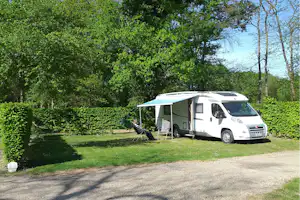 Camping La Forêt - Breiter Wohnwagenstellplatz unter den Bäumen auf dem Campingplatz