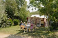 Camping La Grande Plage - Zeltplatz mit essender Familie im Vordergrund