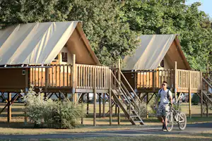 Camping La Gâtine - Camper mit Fahrrad auf dem Gehweg entlang der Mobilheime vom Campingplatz