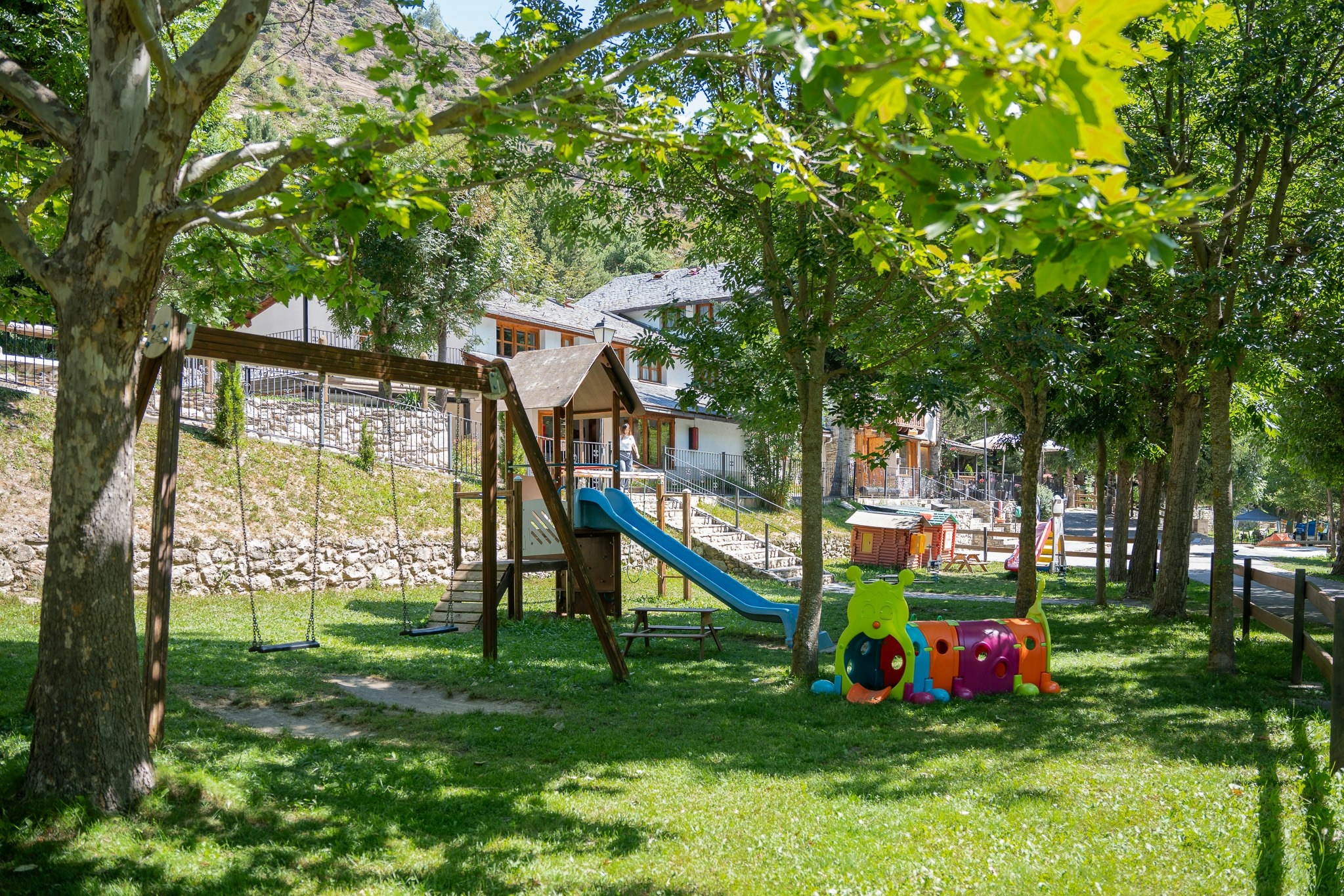 Camping La Mola - Spielplatz unter Bäumen auf dem Campingplatz