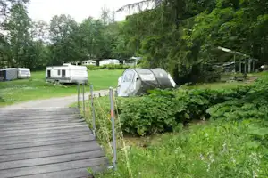 Camping La Murée - Wohnwagen- und Zeltstellplatz zwischen Bäumen auf dem Campingplatz