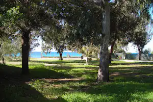 Camping La Palma - Wohnwagen- und Zeltstellplatz zwischen Bäumen mit Blick auf das Mittelmeer im Hintergrund