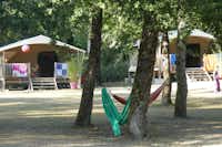 Camping La Palombière - zwei Hängematten in den Bäumen auf dem Campingplatz