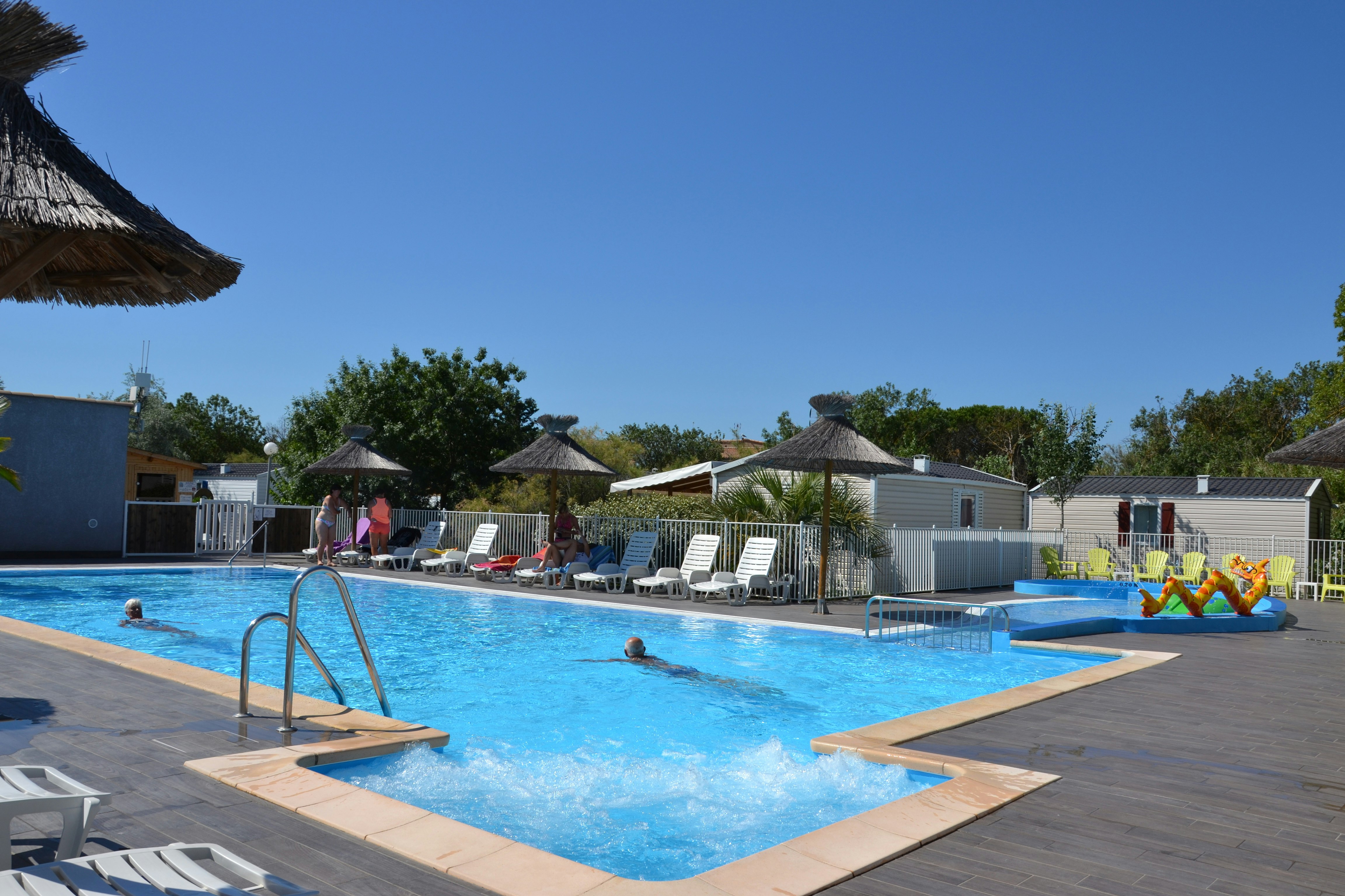 Camping La Pépinière  - Pool im Freien mit Liegestühlen und Sonnenschirmen