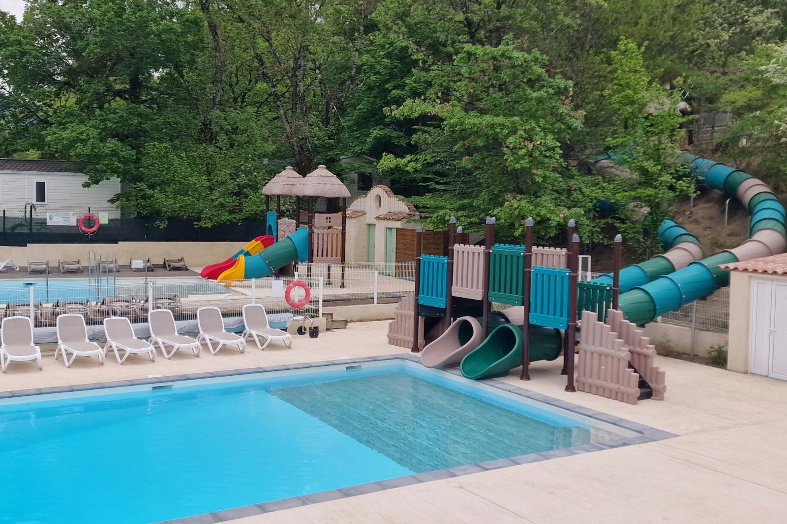 Camping La Pinède - Freibad mit Rutschen und Liegestühlen