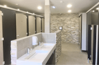 Camping La Plage de Treguer - Innenraum des Sanitärgebäudes  mit Toilettenkabinen, Waschbecken und Spiegeln