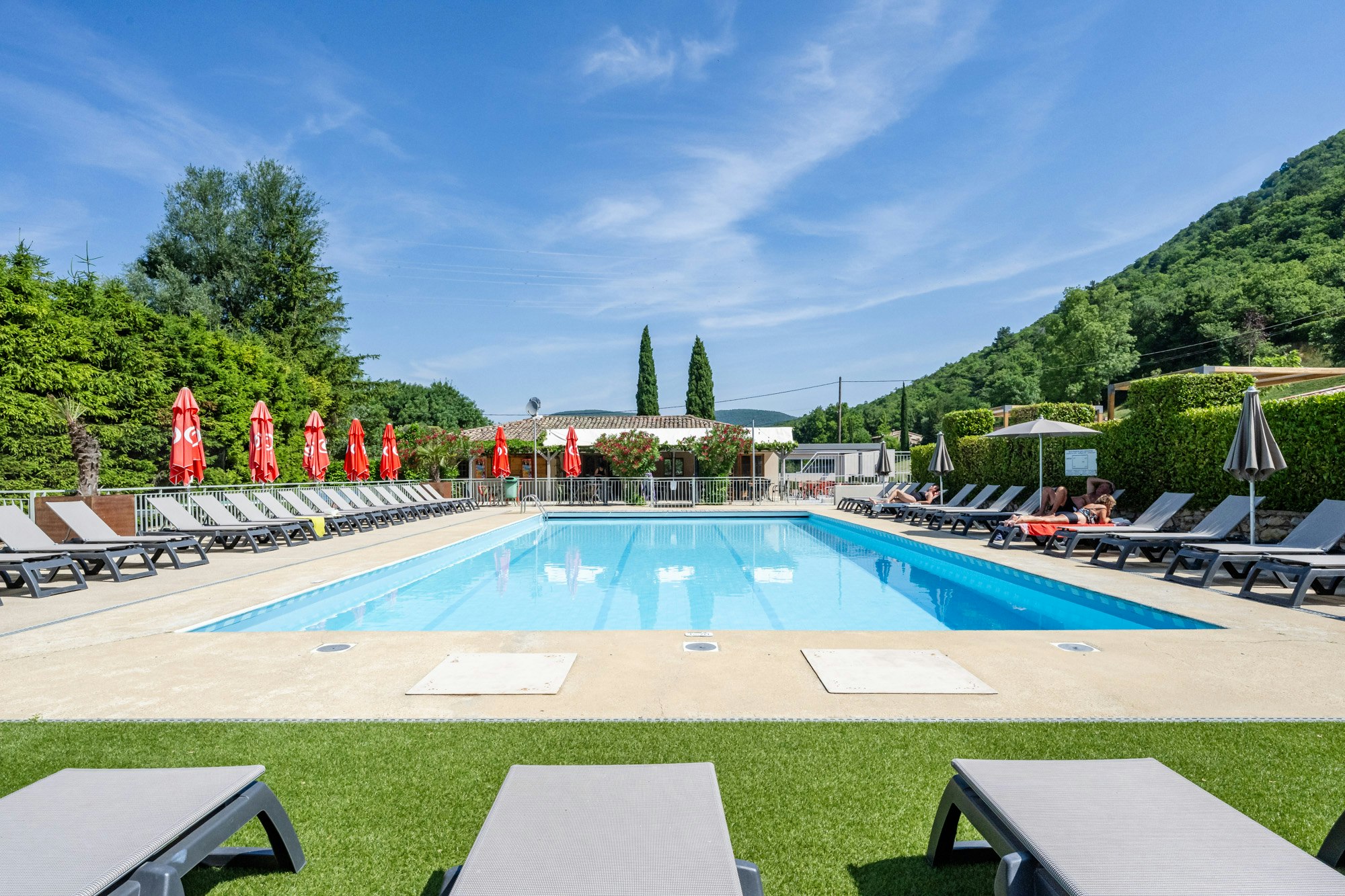 Camping Porte de Provence  - Pool im Freien mit Liegestühlen und Sonnenschirmen