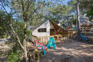 Camping La Presqu'île de Giens - Mobilheim mit Terrasse zwischen Bäumen auf dem Campingplatz