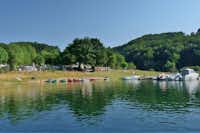 Camping La Romiguière - am See geparkte Kajaks und Motorboote