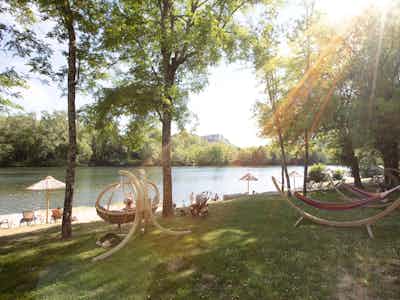 Camping La Roubine - Hängematten zwischen den Bäumen mit Blick auf den Fluss Ardeche auf dem Campingplatz
