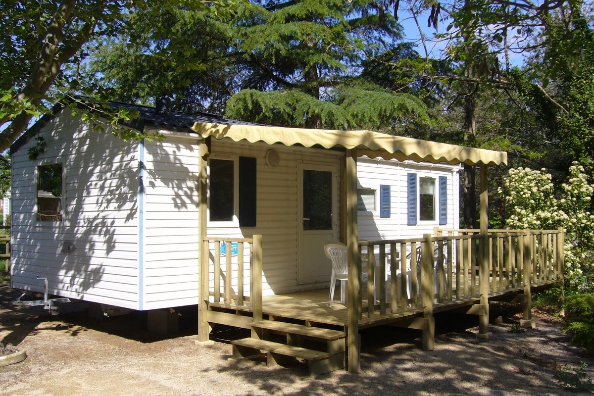Camping La Turelure - Mobilheim mit überdachter Veranda auf dem Campingplatz