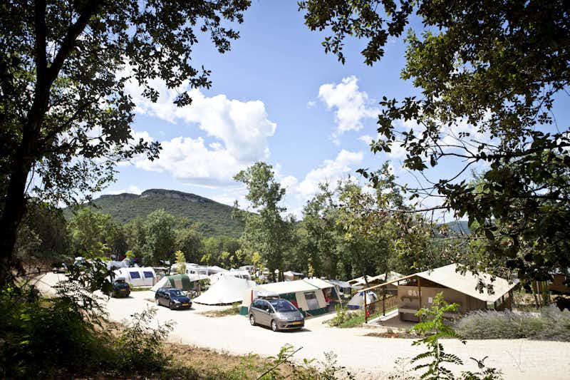 Camping La Vallée Verte  -  Wohnwagen- und Zeltstellplatz zwischen Bäumen auf dem Campingplatz