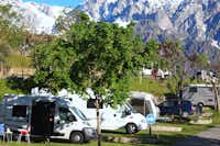 Camping La Viorna  -  Wohnwagenstellplatz und Wohnmobilstellplatz vom Campingplatz zwischen Bäumen auf grüner Wiese
