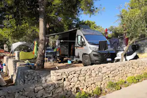 Camping Labadusa - Wohnwagen- und Zeltstellplatz vom Campingplatz zwischen Bäumen