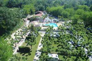 Luftaufnahme eines Campingplatzes mit Pool, Stellplätzen und Wohnwagen, umgeben von viel Grün und Bäumen.