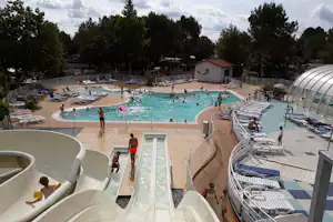 Camping L'Airial - Pool vom Campingplatz mit Wasserrutsche und mit Liegestühlen in der Sonne