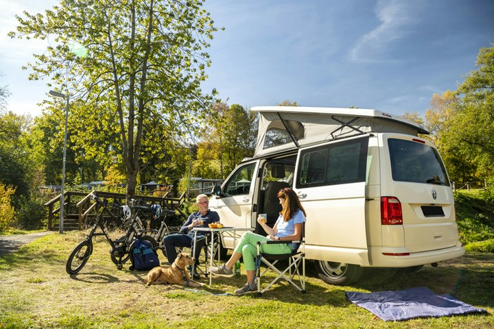 Camping Landal Wirfttal - Camper mit Hund am Wohnmobil auf dem Stellplatz vom Campingplatz im Grünen