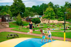 Camping Landal Wirfttal - Camper auf dem Air-Trampolin vom Spielplatz auf dem Campingplatz, Minigolfanlage im Hintergrund