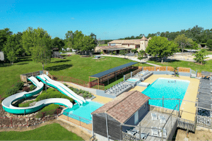 Camping Las Patrasses - Pool im Freien mit Liegestühlen und Sonnenschirmen