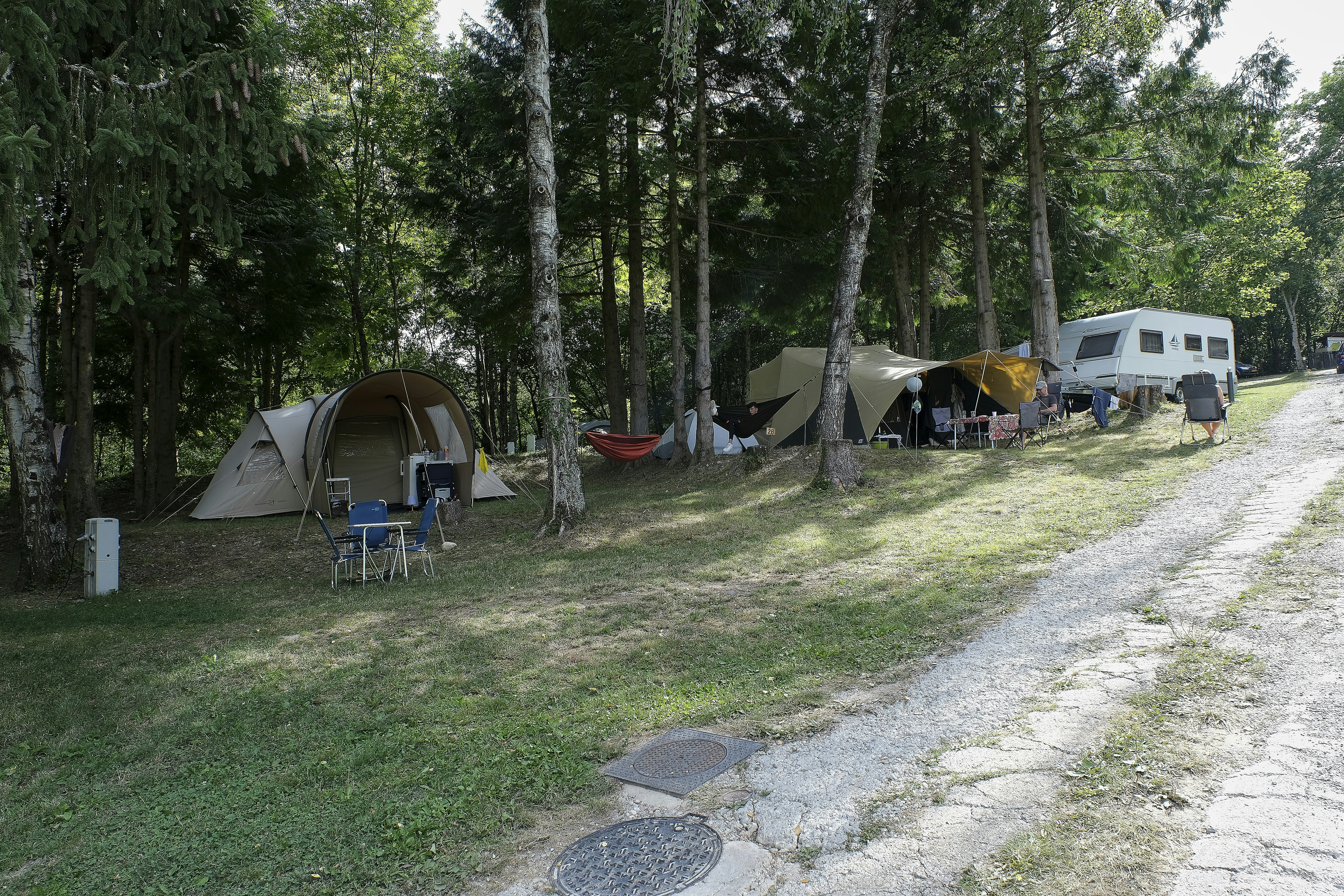Camping l'Aventure - Standplätze unter Bäumen auf dem Campingplatz