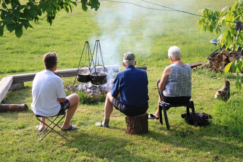 Camping Lazy - Camper beim kochen im Freien an der Feuerstelle