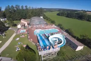 Camping Le Bois de Reveuge - Campingplatz mit Pool,Wasserrutsche, Liegestühlen und Sonnenschirmen