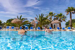 Camping Le Cabellou Plage - Pool mit Liegestühlen und Sonnenschirmen auf dem Campingplatz